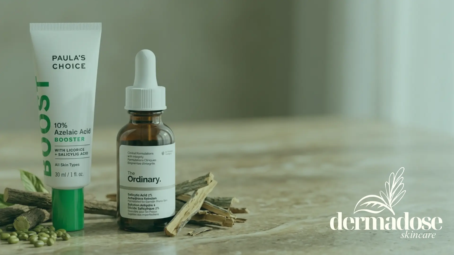 Paula's Choice 10% Azelaic Acid Booster y The Ordinary Salicylic Acid 2% junto a ramas de regaliz y semillas sobre mármol, comparativa de ácido azeláico y salicílico para el acné