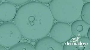 Burbujas de aceite en agua en tonos verdes representando la textura de ácidos exfoliantes como el ácido salicílico o el ácido azeláico para piel con acné
