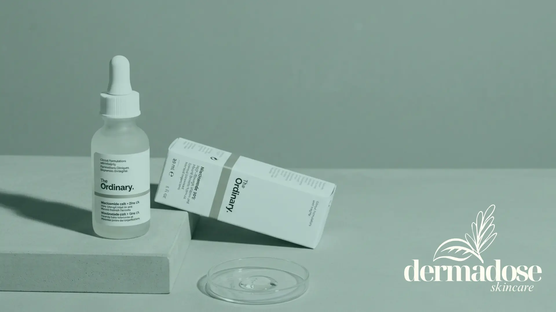 The Ordinary Niacinamide 10% + Zinc 1% frasco y caja sobre superficie gris con placa de Petri con textura del sérum